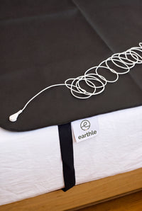 Esterilla de conexión a tierra Earthle con el cable enrollado encima, 185 x 137 cm